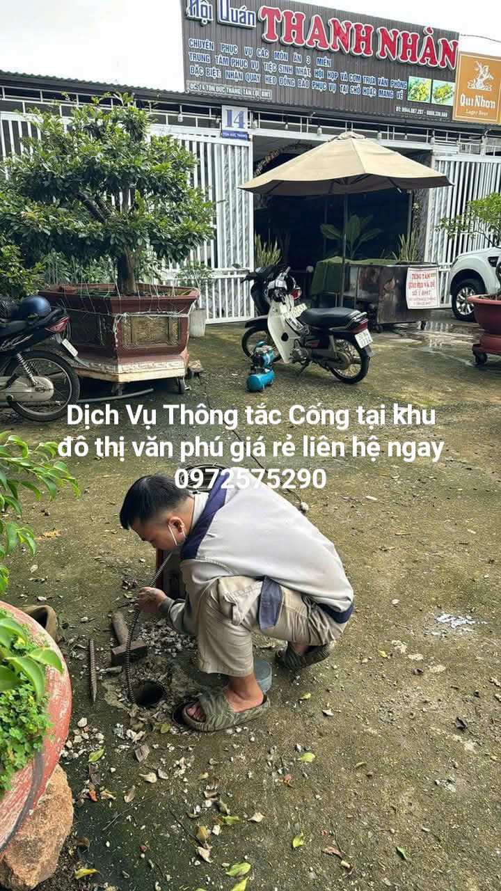 Thợ dùng máy lò xo thông tắc cống tại Văn Phú
