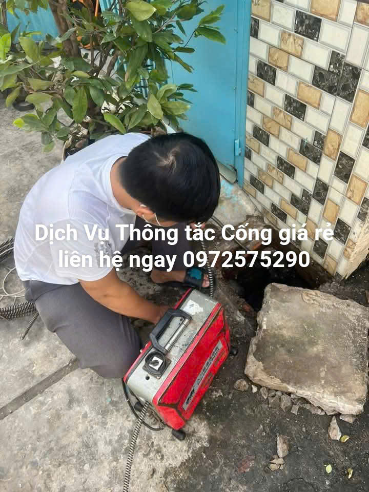 Thợ dùng máy lò xo thông tắc cống tại Kim Văn Kim Lũ