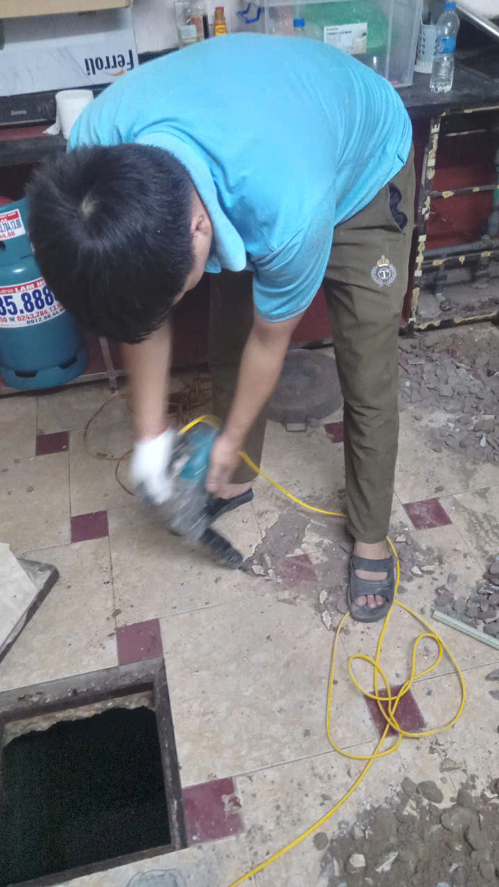 Thợ đang đục và làm lại đường ống nước tại Văn Quán